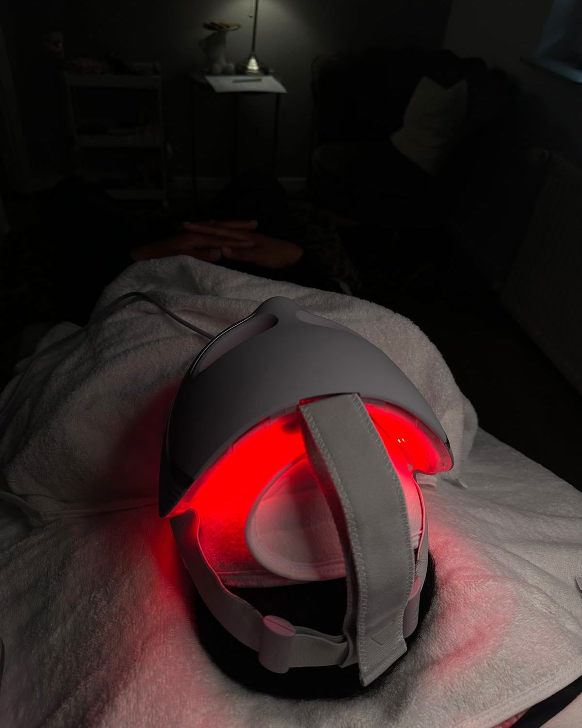 Kundin mit LED-Lichttherapie-Maske während einer Gesichtsbehandlung