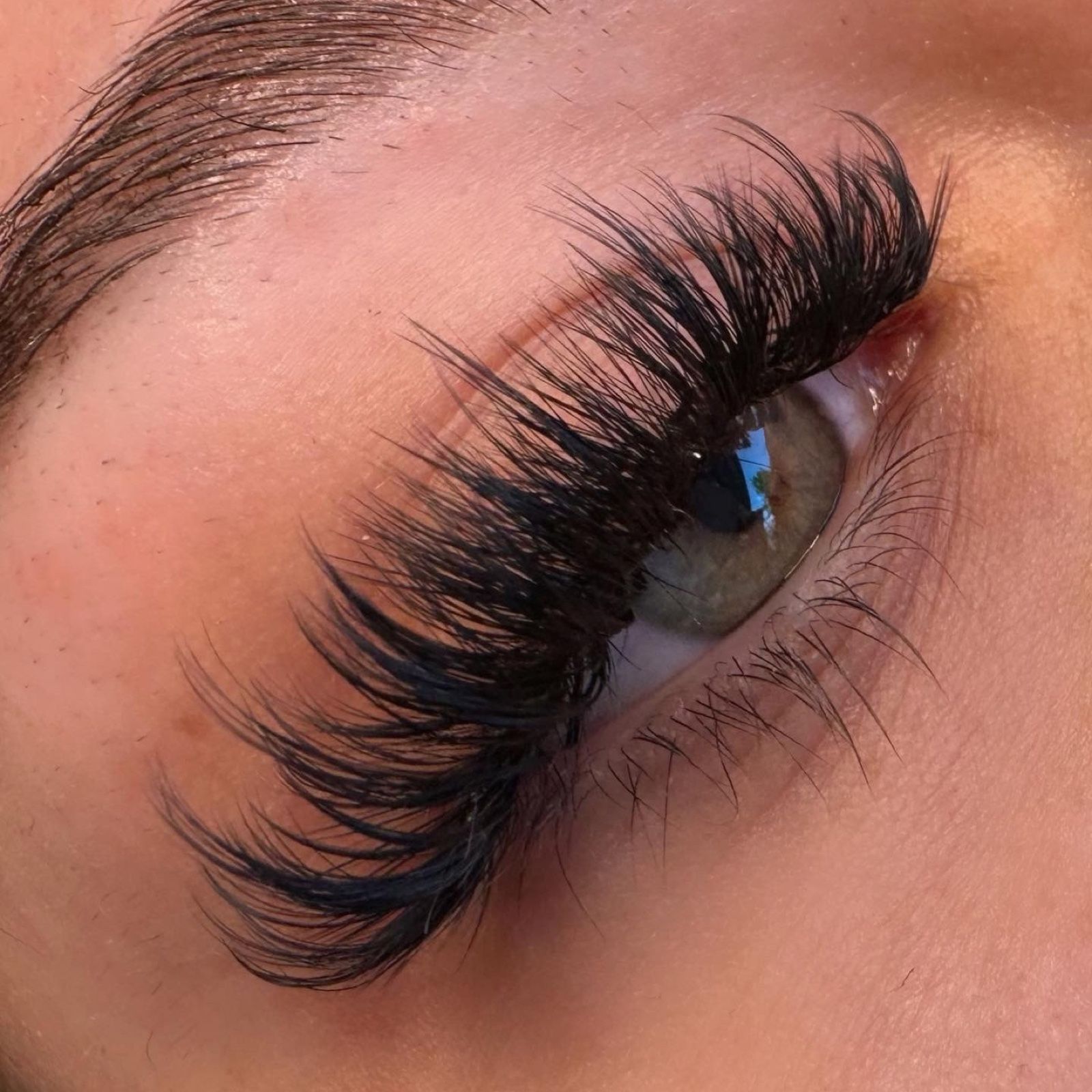 Volumen-Wimpern an einem blaugrauen Auge